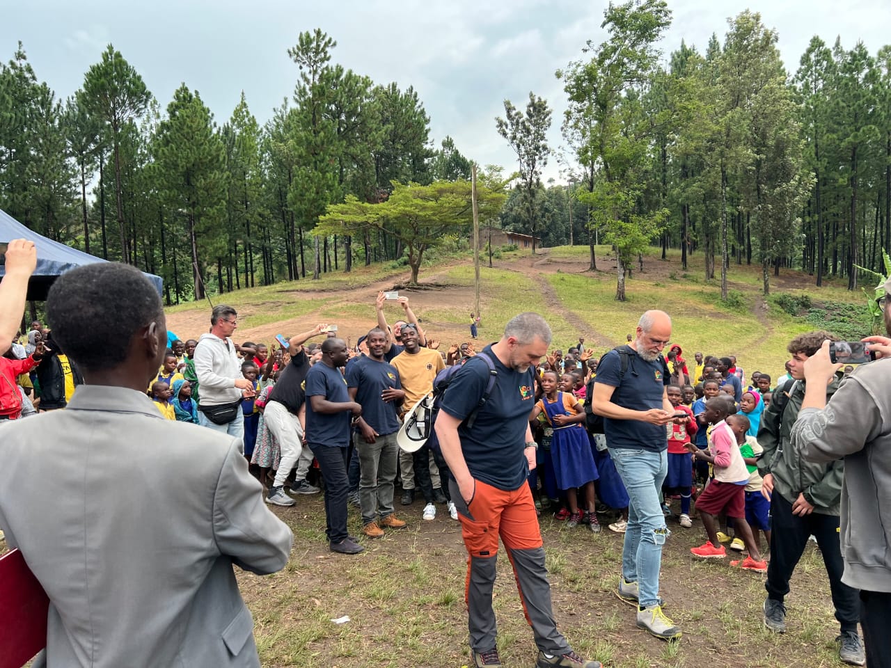AICO ODV visitors and local children gathered during a community visit in Uganda